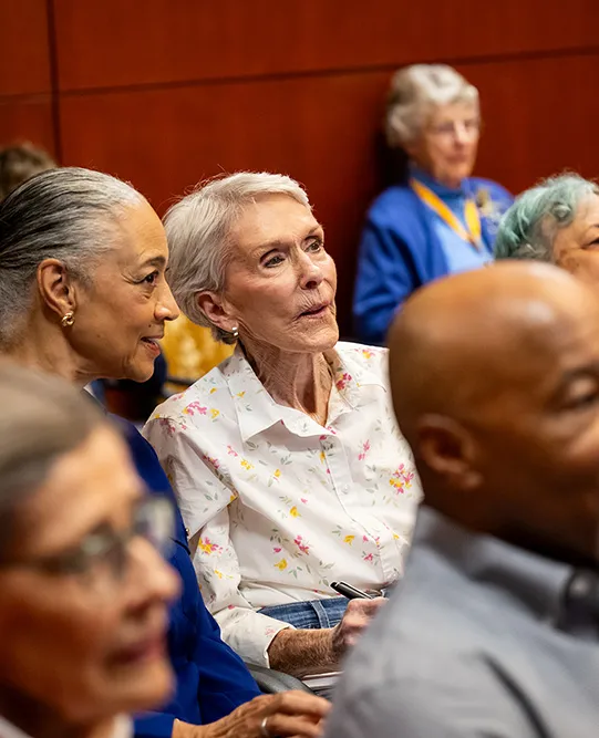 Edenwald_homepage_college-enriched-senior-living Two senior women attending an education seminar