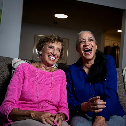 Edenwald_Programs-Events_entertainment-social Two older women laughing together watching a movie