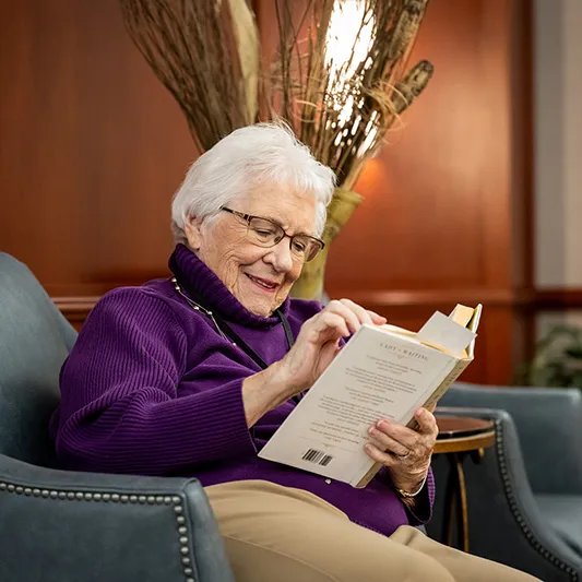 Edenwald_Programs-Events_faith-based A senior woman relaxing reading a book