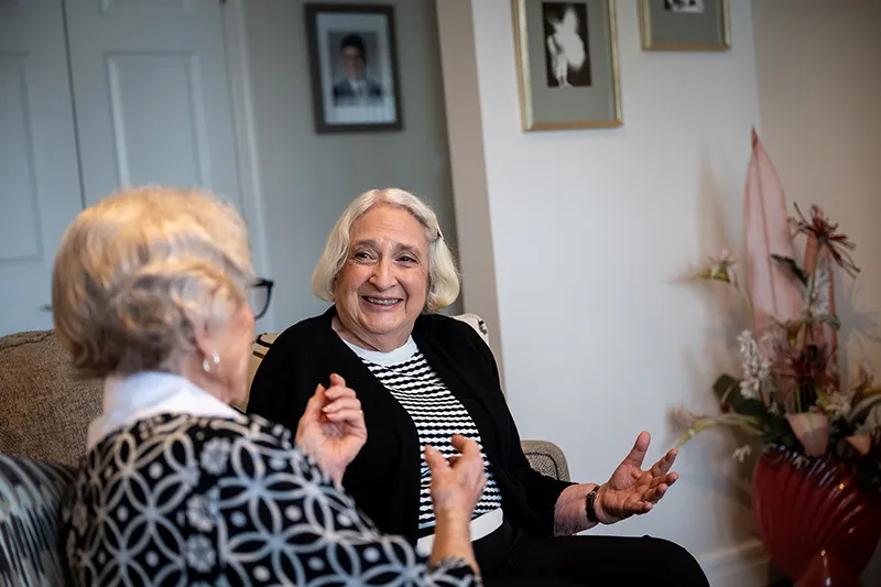 Two senior women laughing having a conversation together