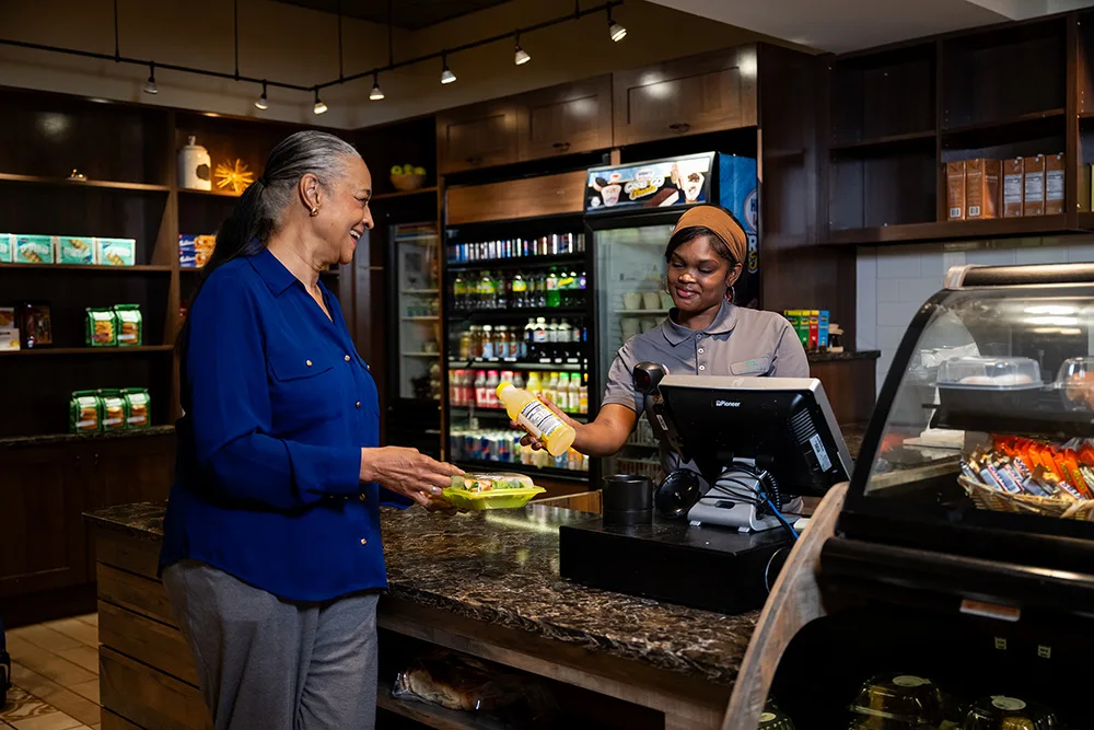Edenwald_Dining_Flex-Dining (1) A senior woman purchasing a snack at a cafe