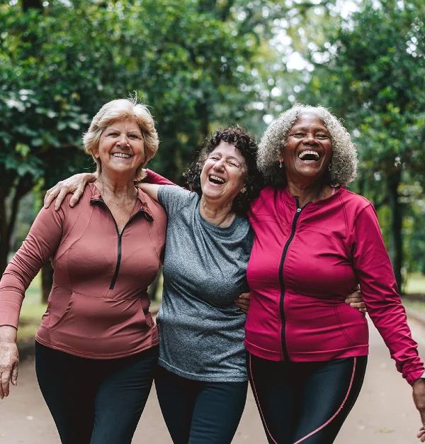 homepage_Non-Profit-Mission-mobile Three senior women smiling walking in a park