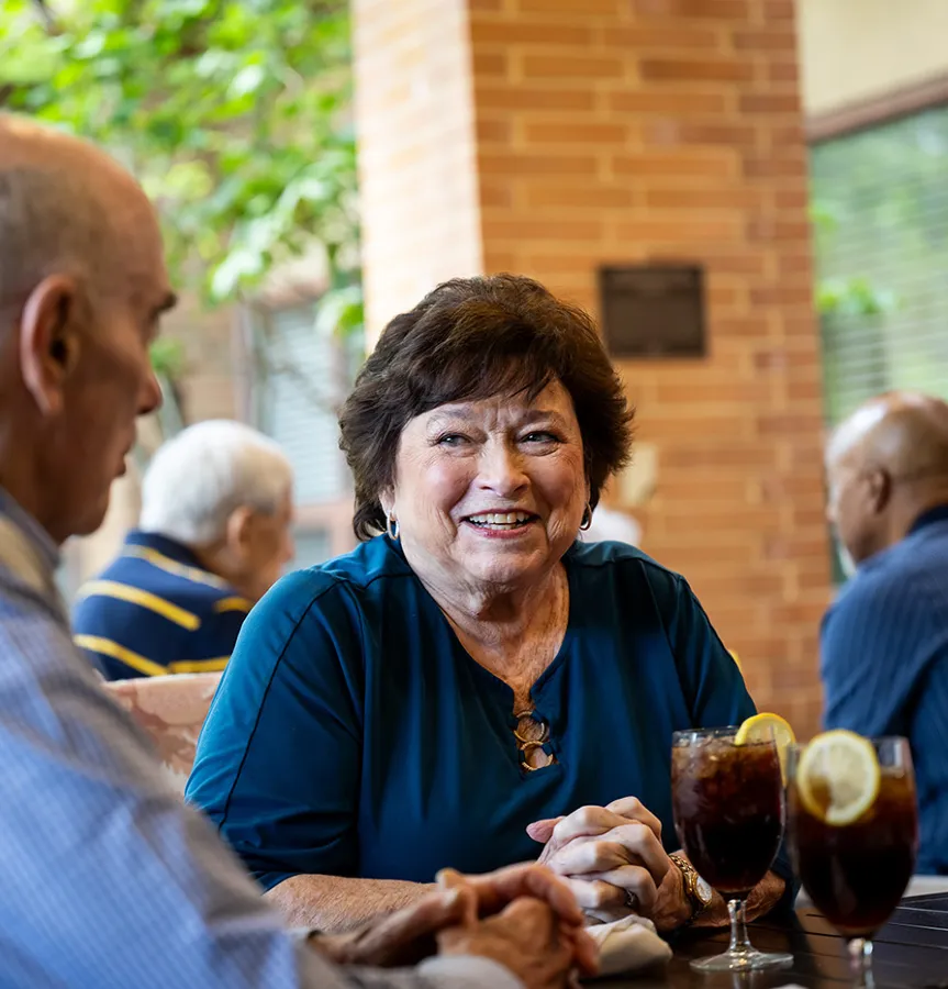 homepage_grille Woman smiling at a dining table with a man
